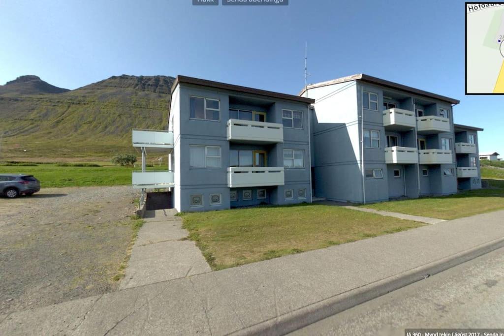 um prédio de apartamentos com um carro estacionado em frente em Súðavík apartment em Súðavík