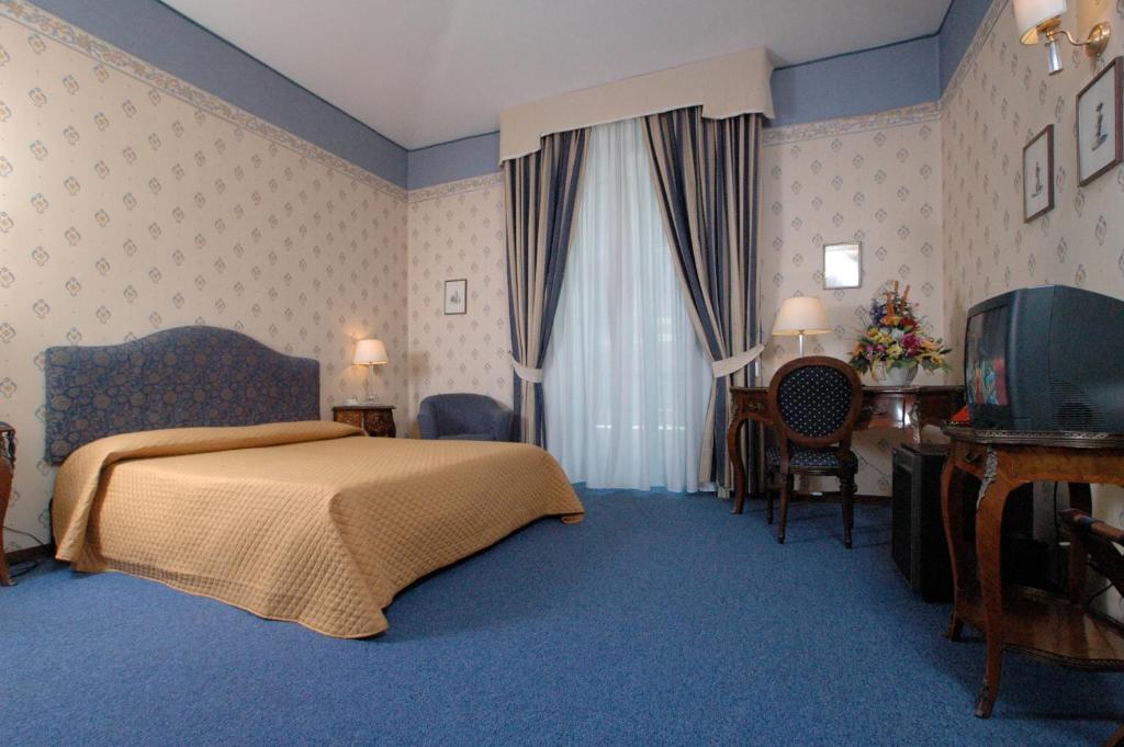 una camera d'albergo con letto e TV di Hotel Nuovo Rebecchino a Napoli
