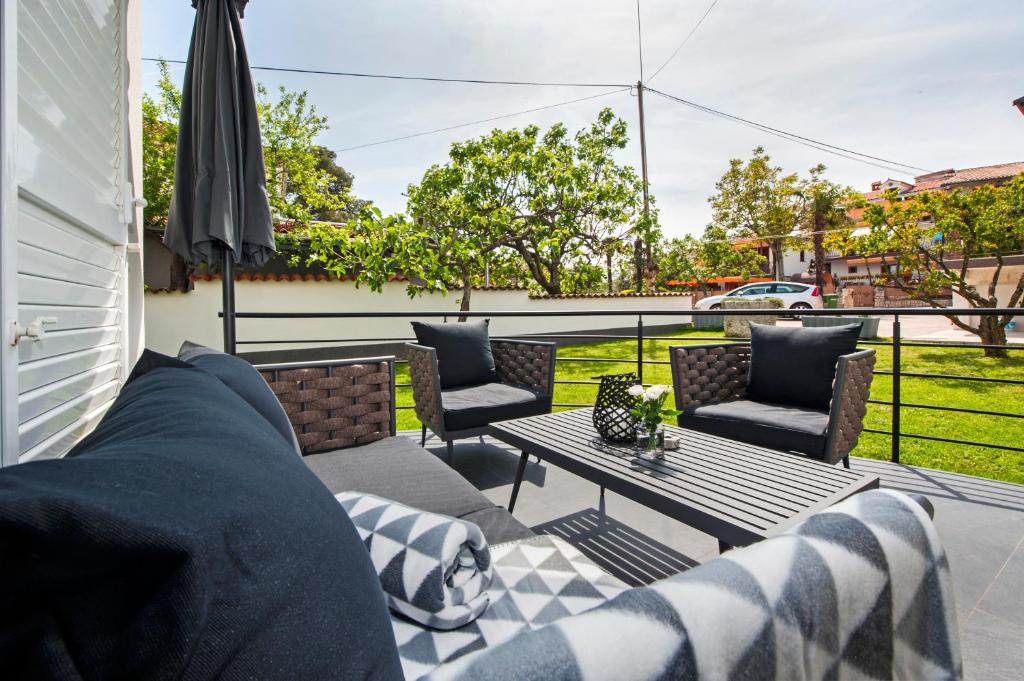 a patio with a couch and a table and chairs at Apartment Margita in Rovinj