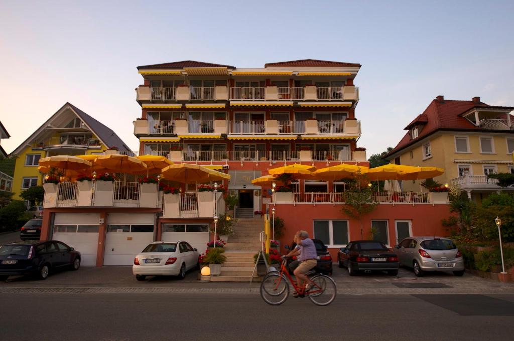 a person riding a bike in front of a building at Seehotel OFF in Meersburg