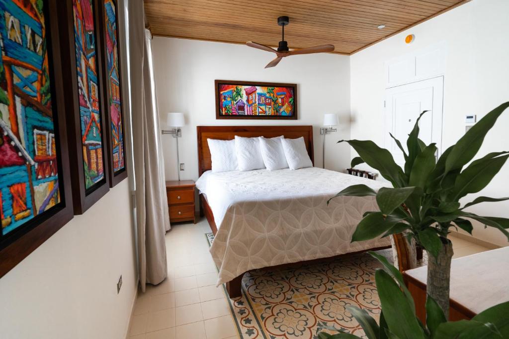 a bedroom with a bed and a potted plant at Casa Wilson Inn in San Juan