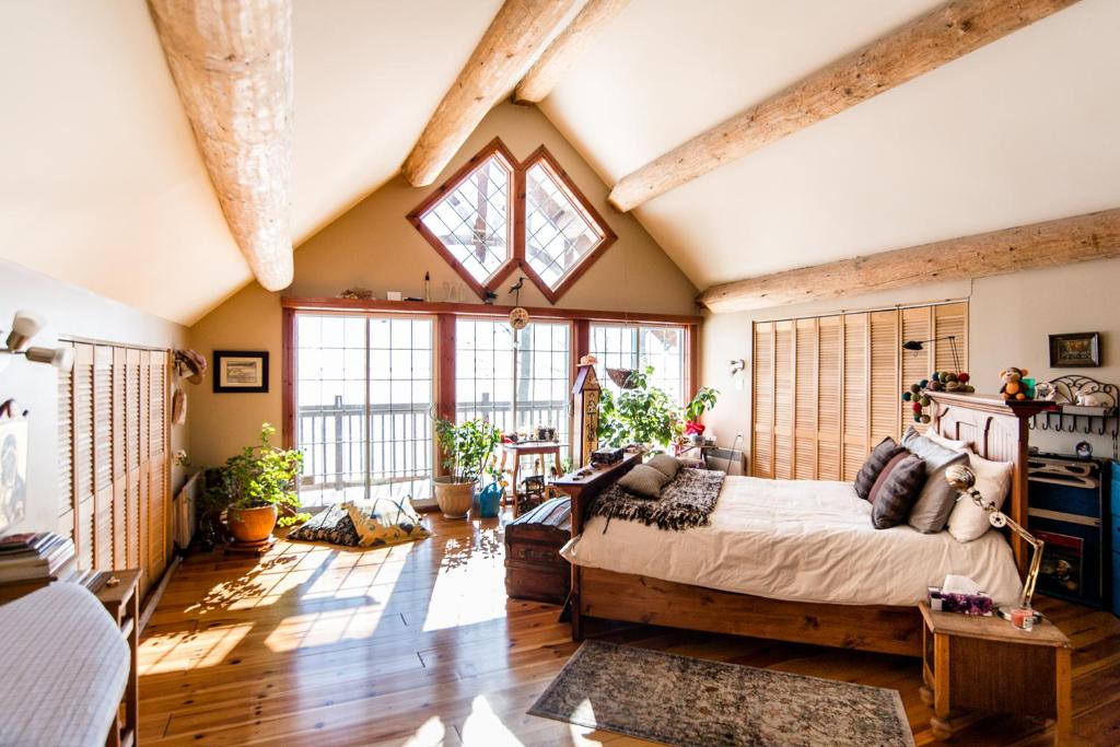 a bedroom with a large bed and a large window at Le petit Montebello in Grenville-sur-la-Rouge