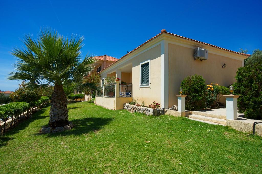 a house with a palm tree in the yard at Eleftheria Apartments in Vlachata