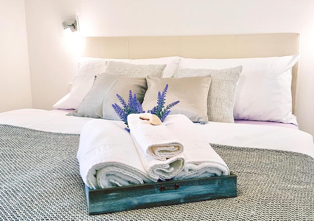 ein Bett mit weißer Bettwäsche und Handtüchern darauf in der Unterkunft Orkula Apartments in Pašman