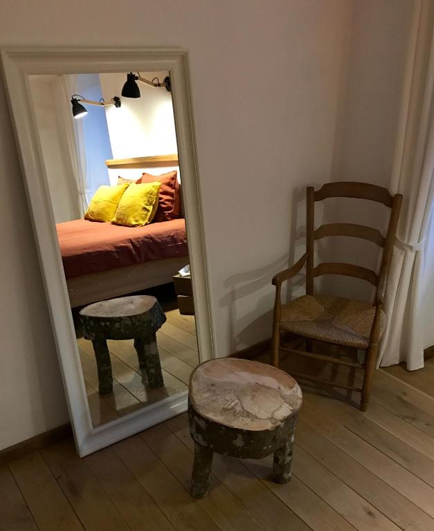 a bedroom with a mirror and a bed and a chair at Chambre à la ferme in Précy-le-Sec