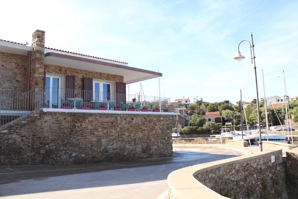 a stone building with a balcony on a street at 103 Boutique Hotel Stintino in Stintino