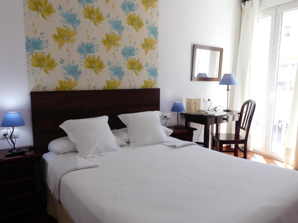 A bed or beds in a room at Hostal La Andaluza