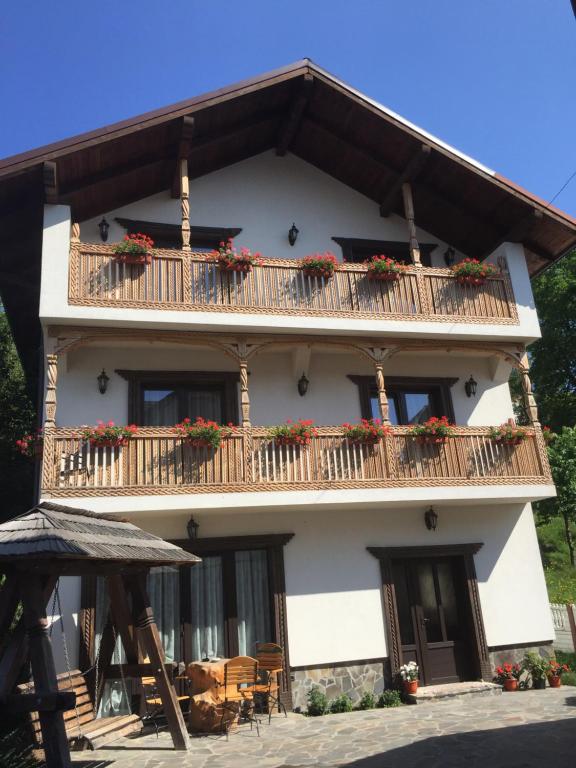 - un bâtiment avec un balcon fleuri dans l'établissement Pensiunea Rustic, à Borşa