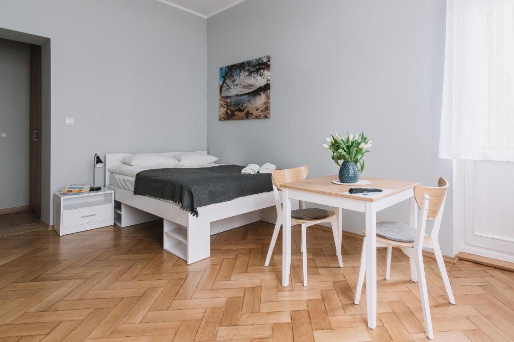 Schlafzimmer mit einem Bett und einem Tisch mit Stühlen in der Unterkunft Sopot Host Studio in Sopot