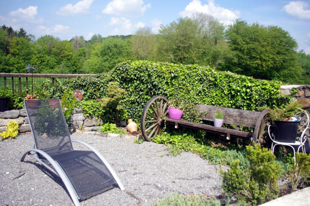 - un jardin avec un vieux banc et une chaise dans l'établissement Gite Avesnois - 4910 -, à Willies