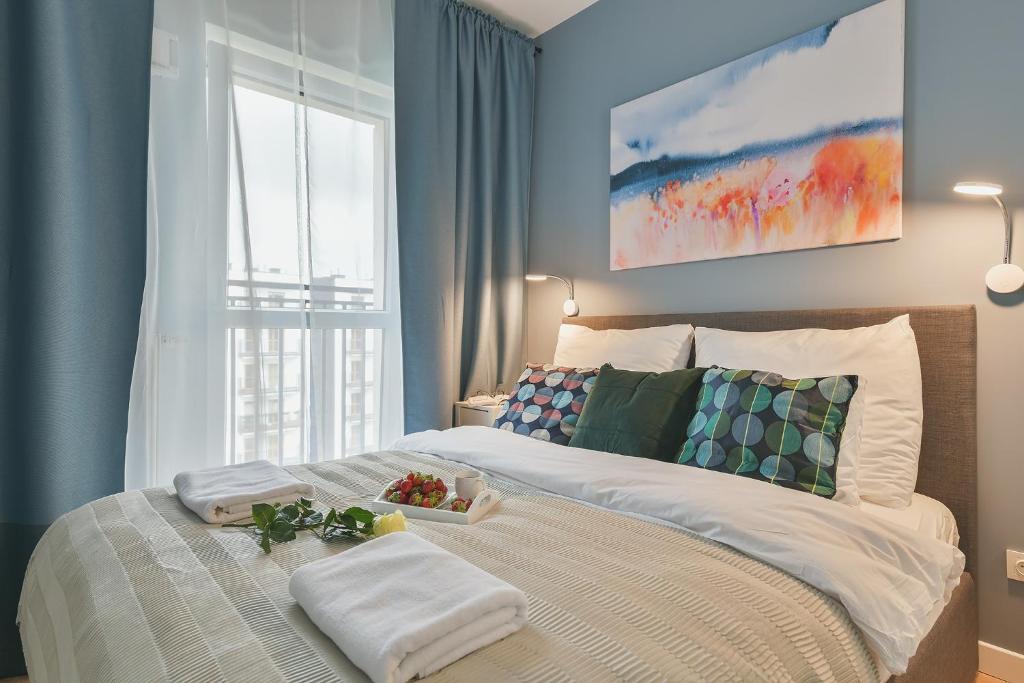 sypialnia z łóżkiem z ręcznikami i oknem w obiekcie Airport Okecie Wagonowa Serviced Apartments w Warszawie
