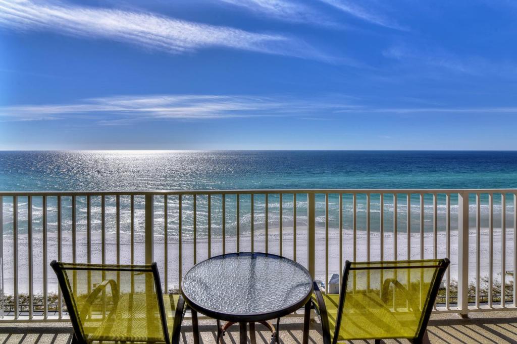 two chairs and a table on a balcony overlooking the beach at Majestic Sun 913A Miramar Beach (Condo) in Destin