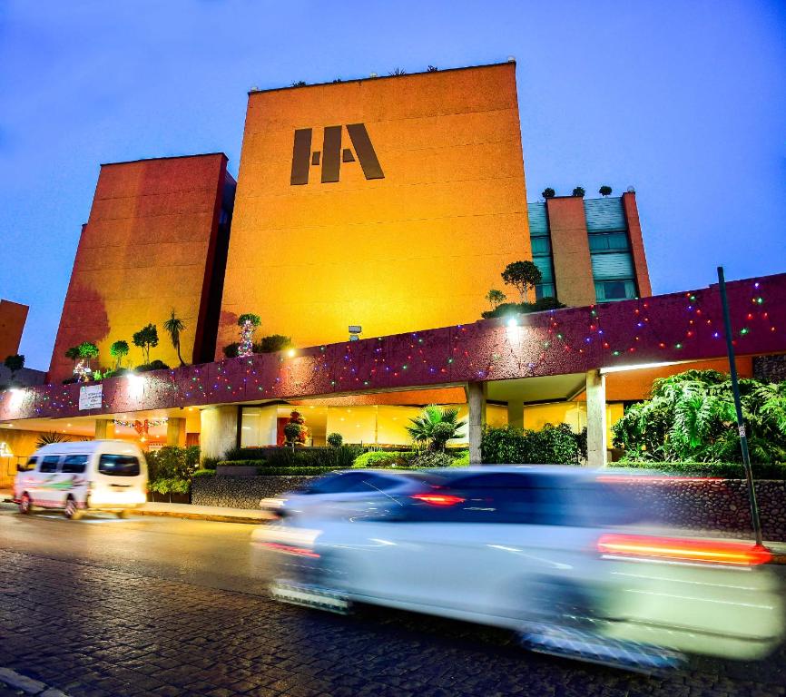 Una macchina che guida lungo una strada di fronte a un edificio di Hotel Atizapan a Città del Messico