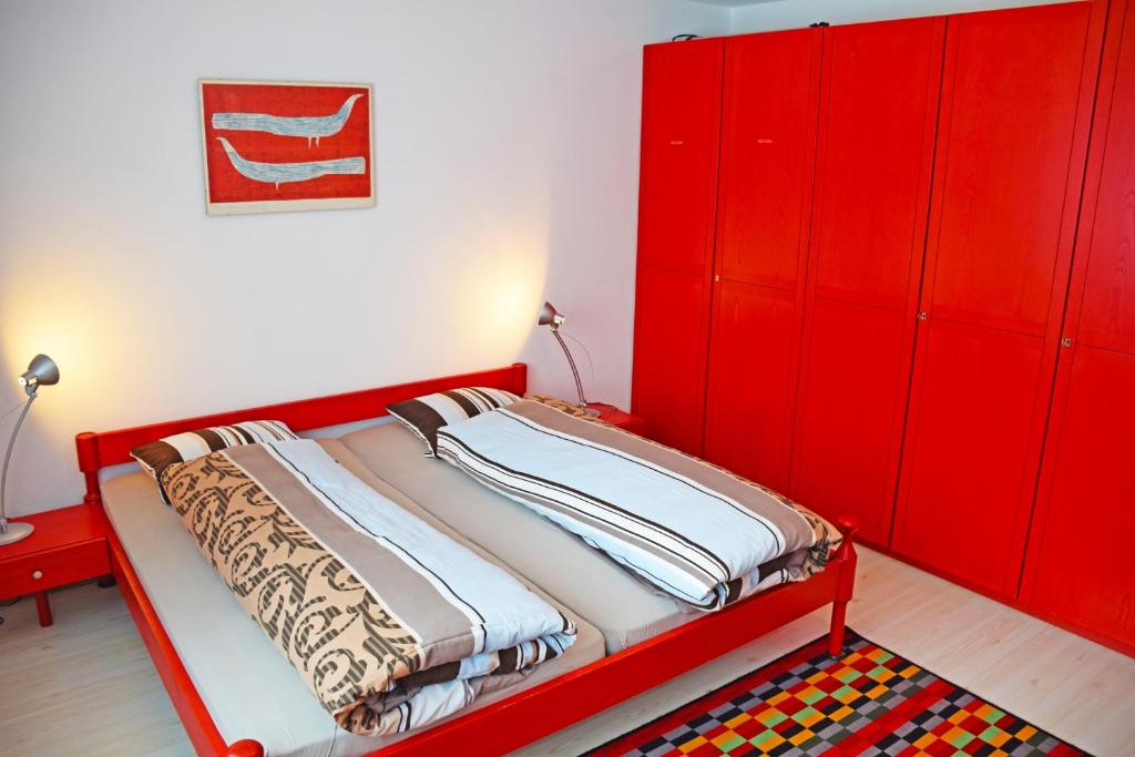 1 dormitorio rojo con 1 cama y armarios rojos en Apartment Center Zermatt, en Zermatt