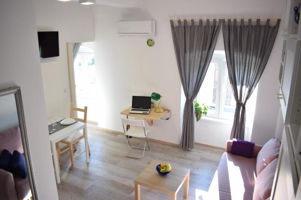 a living room with a couch and a table with a laptop at Apartman ''Nicole'' in Pula