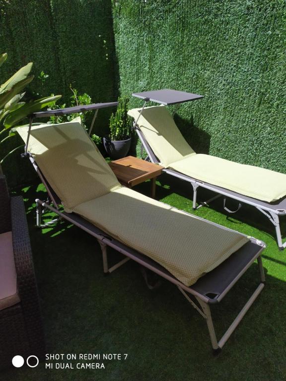 dwa krzesła i parasol na trawie w obiekcie apartment garden w mieście Caldas de Reis