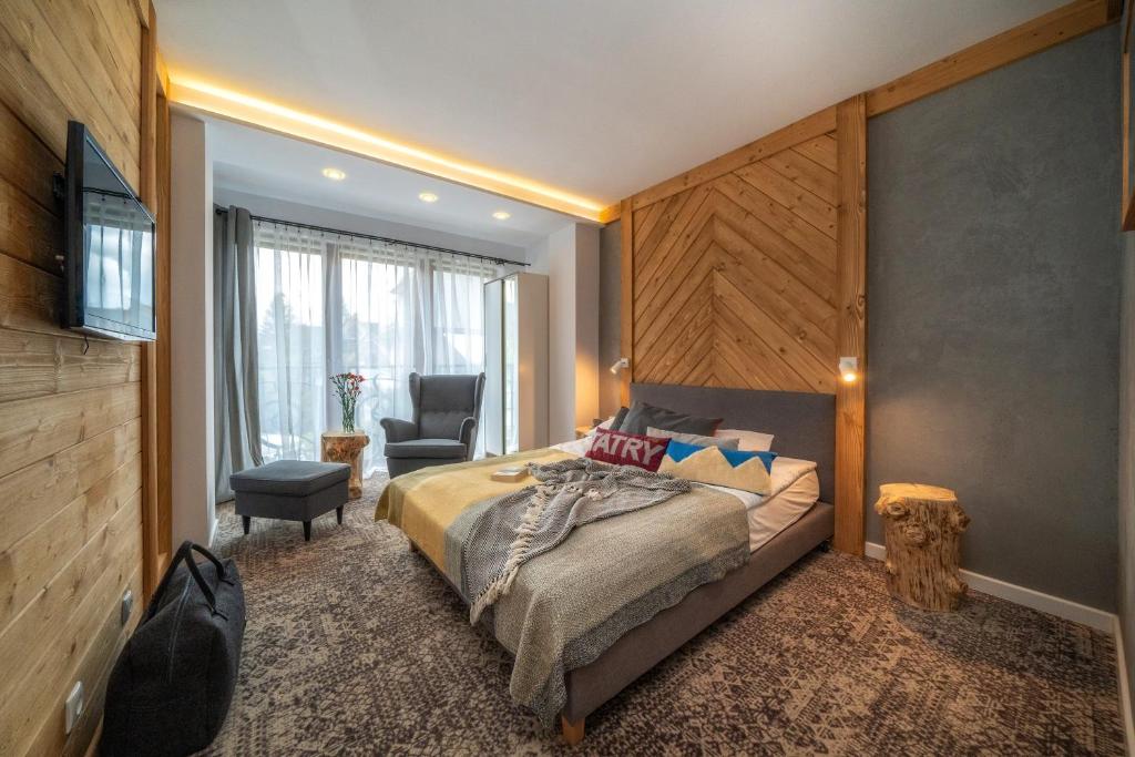 1 dormitorio con 1 cama y 1 silla en una habitación en Willa Piano, en Zakopane