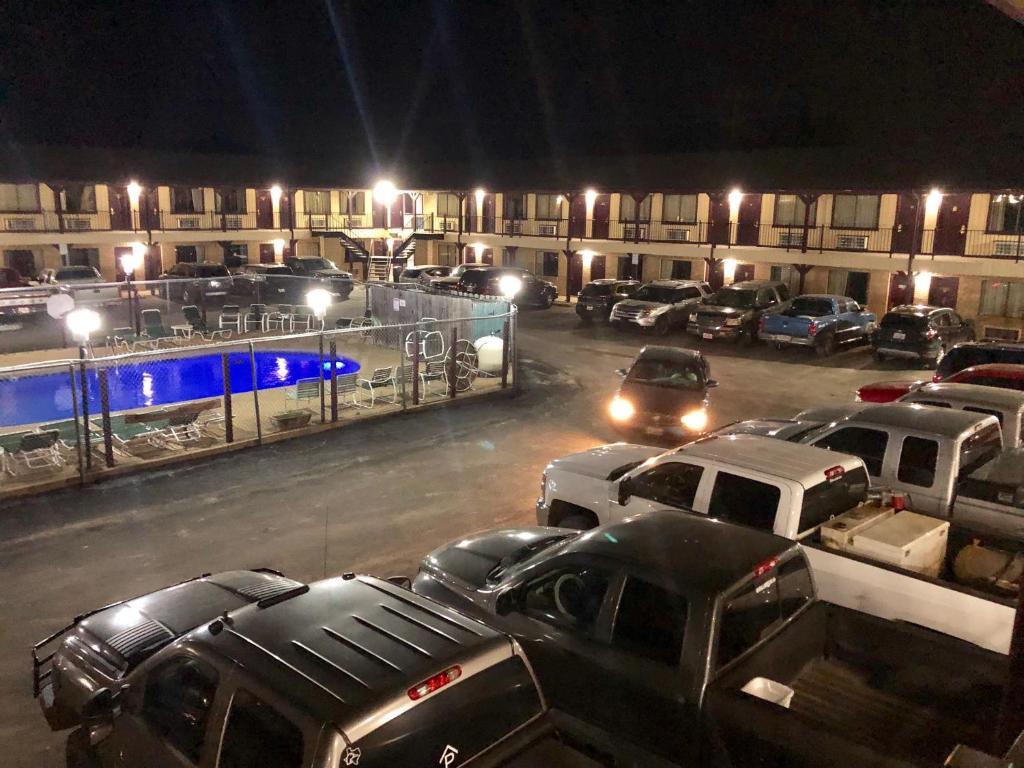 a parking lot with cars parked in front of a building at Inn at Mexia in Mexia