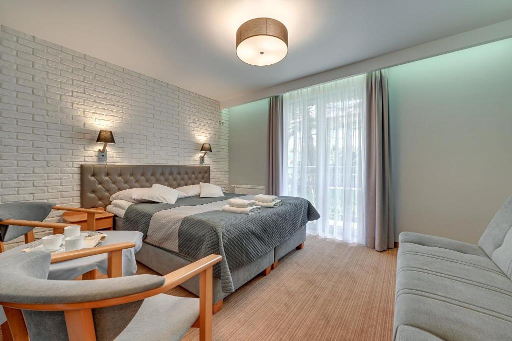 a bedroom with a bed and a living room at Aster in Władysławowo
