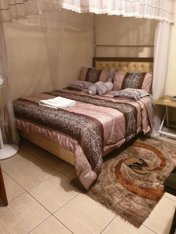 a bed with a stuffed animal on it in a room at Mercy-Phillips Apartments Located at Eagle Tower Building Nairobi City Centre in Nairobi