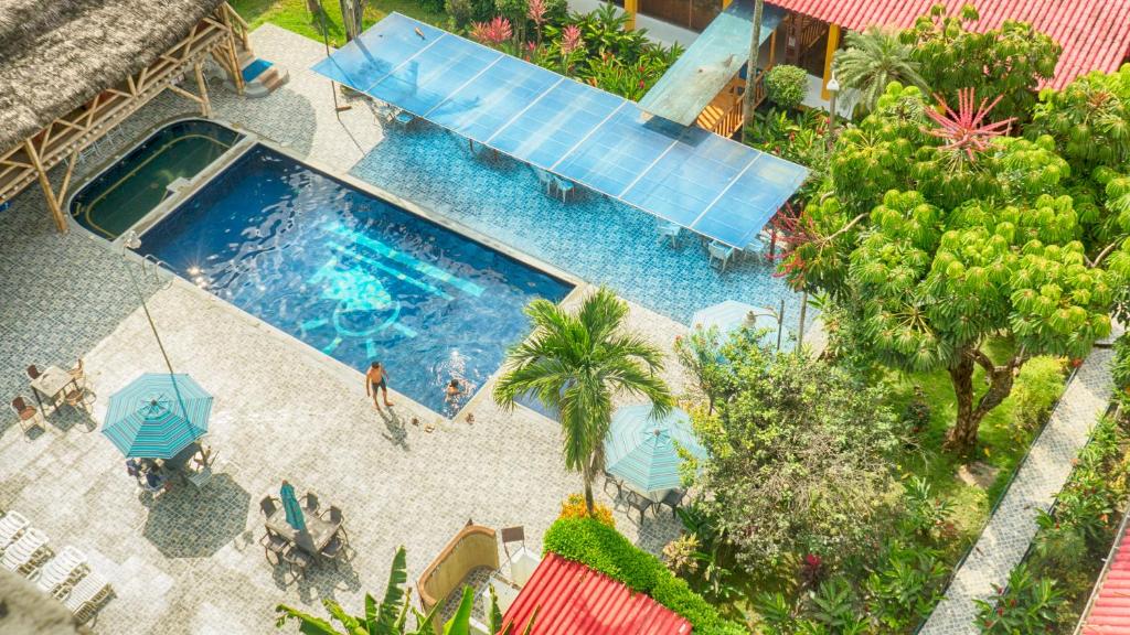 una vista aérea de una piscina con personas y sombrillas en Hotel Puerto Ballesta, en Tonsupa