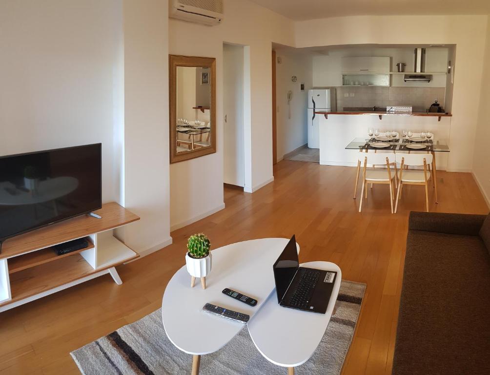 a living room with a table with a laptop on it at Encantador departamento con cochera cubierta in Vicente López