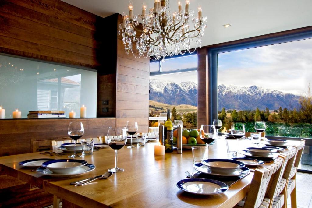 a dining room with a table with wine glasses at Forty Two by Amazing Accom in Queenstown