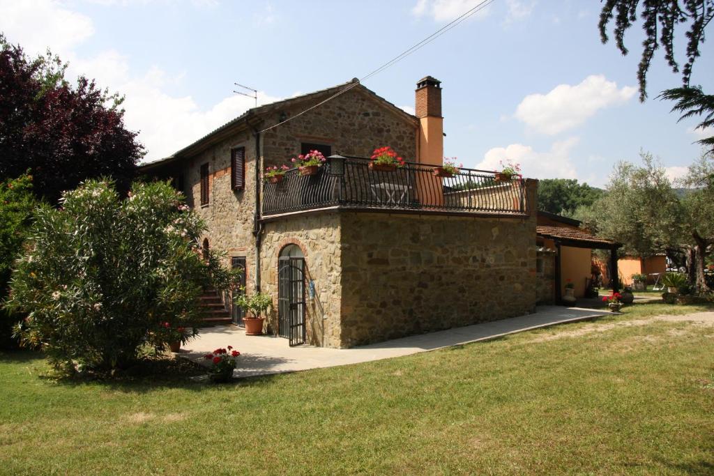 a house with a balcony on the side of it at Al Casolare in Tuoro sul Trasimeno