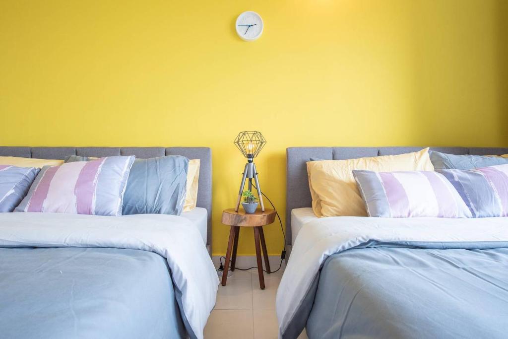 2 camas en una habitación con un reloj en la pared en SetiaWalk {BIG GROUP}12Pax WIFI 2C'Park IOI SUNWAY SUBANG USJ, en Puchong