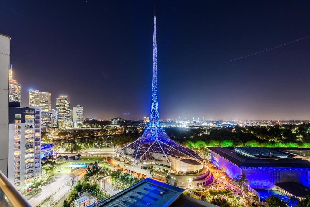 a view of a tower in a city at night at Exclusive Stays - Gallery Penthouse in Melbourne