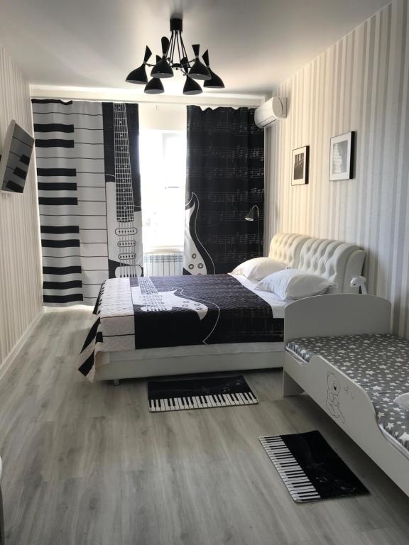 ゲレンジークにあるПриморская улица 1のベッドルーム1室(ベッド1台付)、壁にギターが備わります。