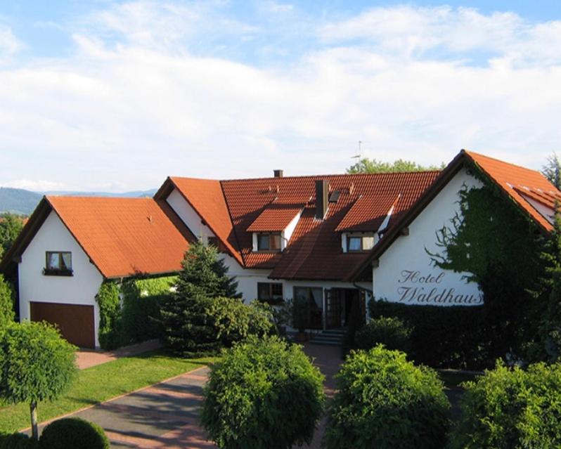 ein großes Haus mit orangefarbenem Dach in der Unterkunft Hotel Waldhaus in Hügelsheim