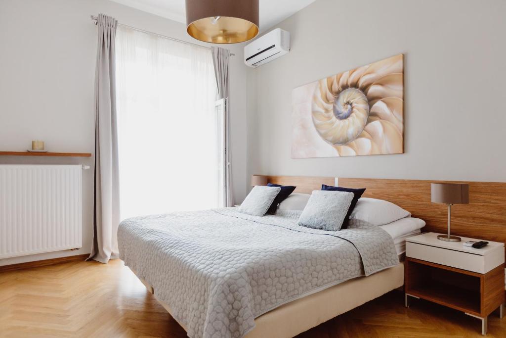 una camera da letto con un letto e un dipinto sul muro di 4Seasons﻿ Apartments Cracow a Cracovia