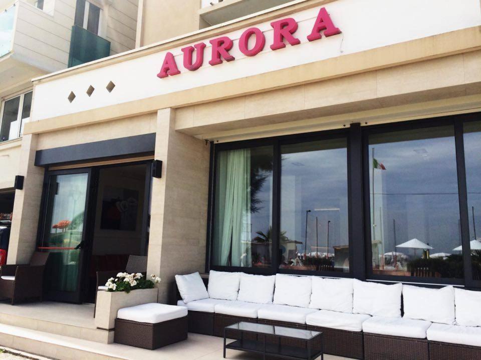 uma loja com um sofá branco sentado do lado de fora em Hotel Aurora em Gabicce Mare