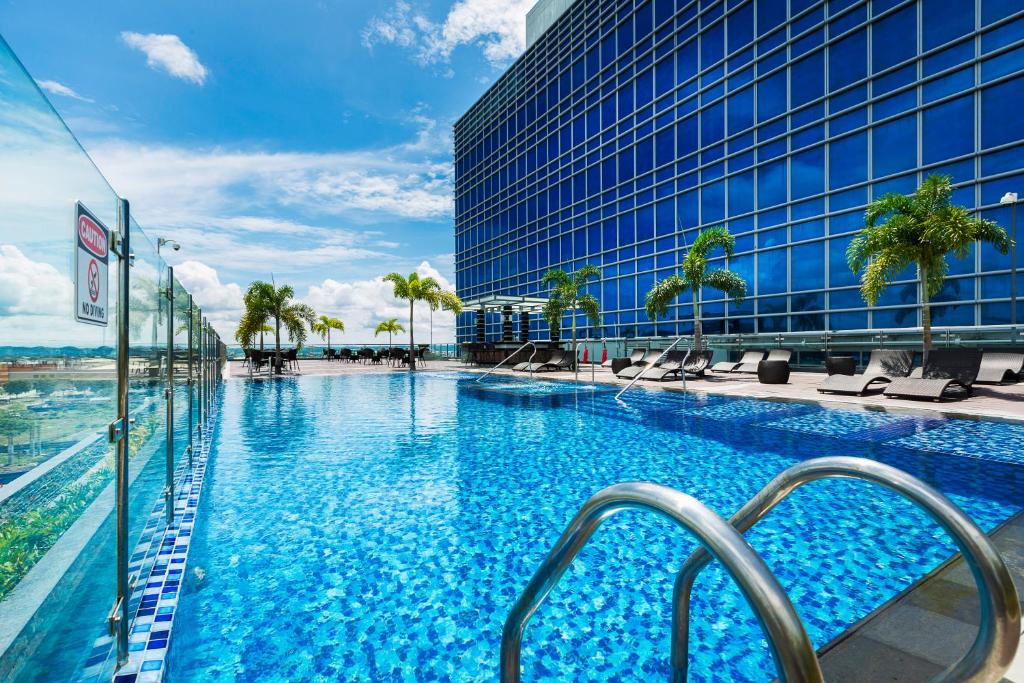 a large swimming pool in front of a building at Richmonde Hotel Iloilo in Iloilo City