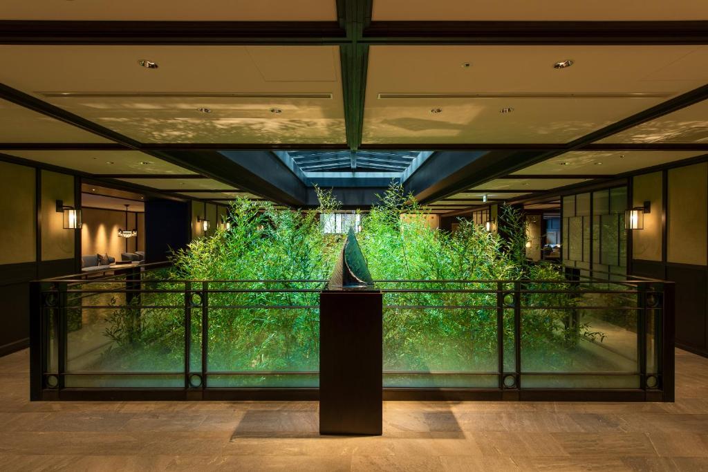 a large green wall in a lobby with a sculpture at Dhawa Yura Kyoto - Banyan Group in Kyoto