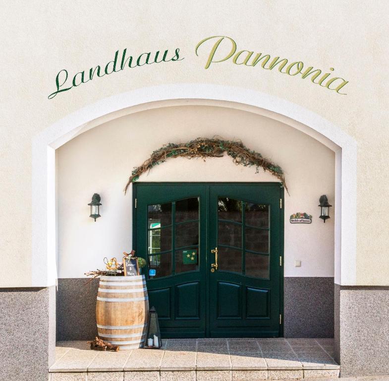 a green door of a wine shop with a barrel at Landhaus Pannonia in Mörbisch am See