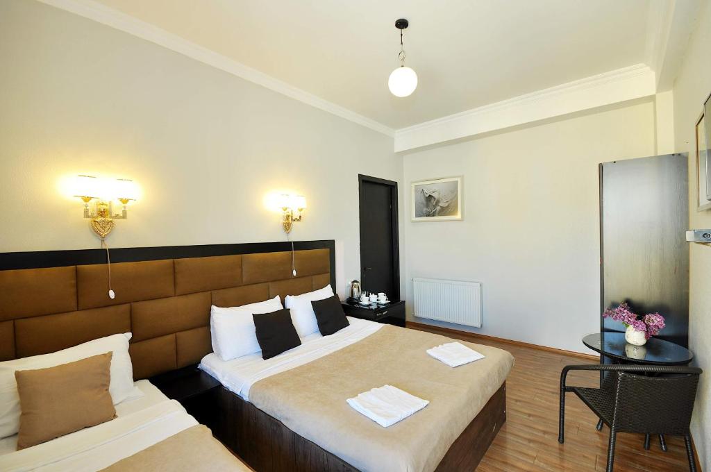Cette chambre comprend 2 lits et une table. dans l'établissement Hotel Marsel, à Tbilissi