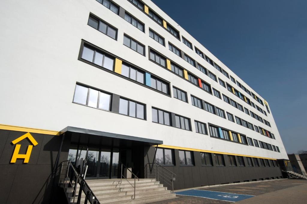 un gran edificio blanco con una A amarilla en él en Apart Hostel, en Poznan