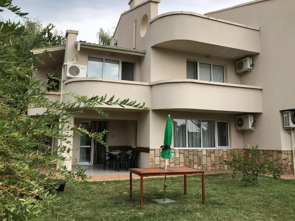 a house with a table and a green umbrella at Sea House in Sveti Vlas