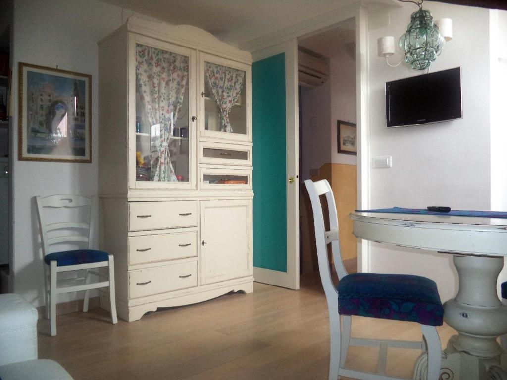 Habitación con armario blanco, mesa y sillas. en Casa Tella en Venecia