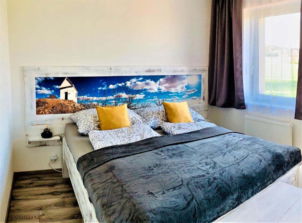 um quarto com uma cama grande e uma pintura na parede em Penzion Holín u Prachovských skal em Jičín