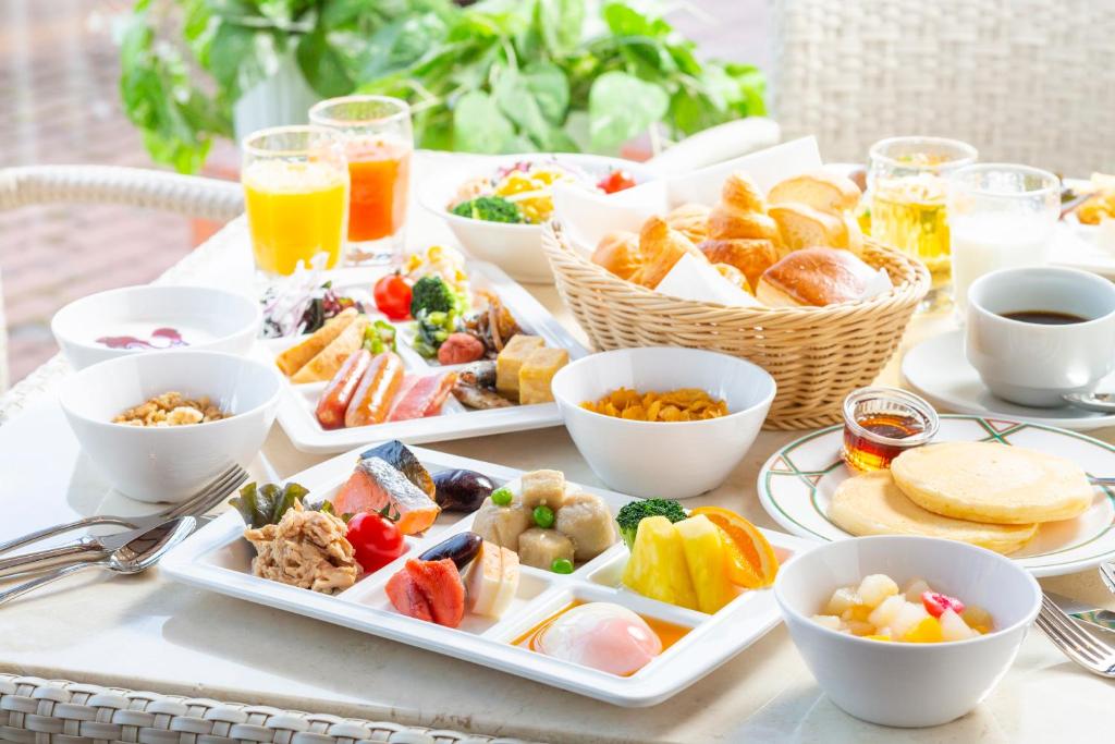 a table with several plates of food and drinks at Kusatsu Onsen Hotel Village in Kusatsu