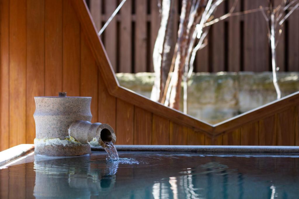 a water fountain sitting on top of a swimming pool at Kusatsu Onsen Hotel Village in Kusatsu