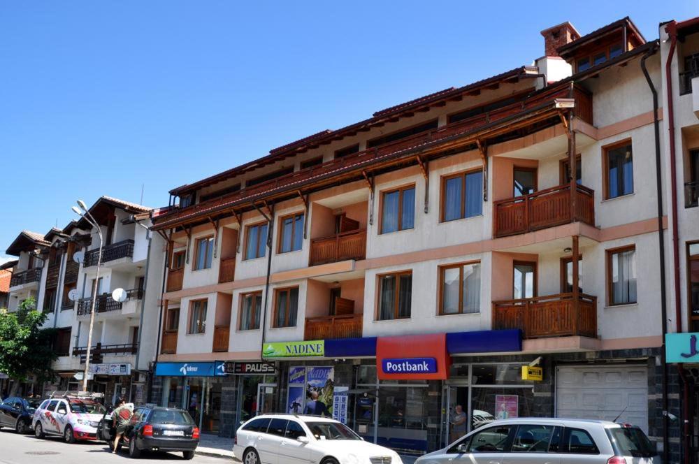 a large building with cars parked in front of it at Family Hotel LILI in Bansko