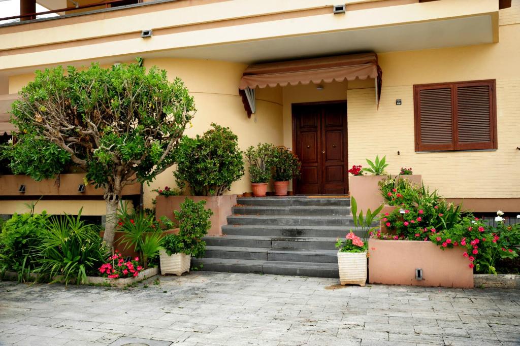 una casa con scale e piante in vaso di fronte ad essa di Civico 34 a Caserta