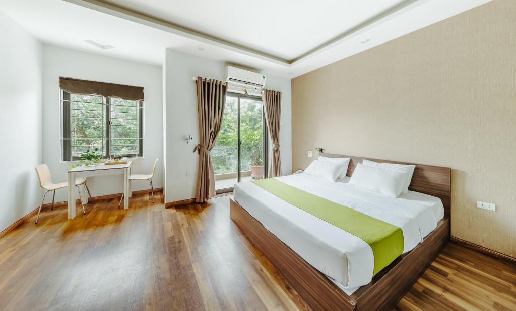ein Schlafzimmer mit einem großen Bett, einem Schreibtisch und einem Fenster in der Unterkunft Hana 1 Apartment & Hotel Bac Ninh in Bắc Ninh