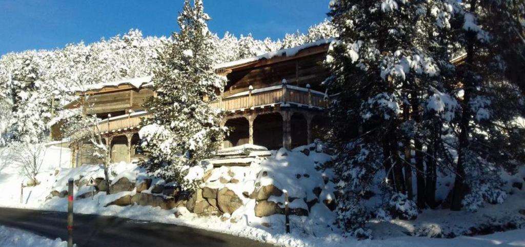 un bâtiment recouvert de neige et d'arbres devant lui dans l'établissement Ker Capcir, à Bolquère-Pyrénées 2000