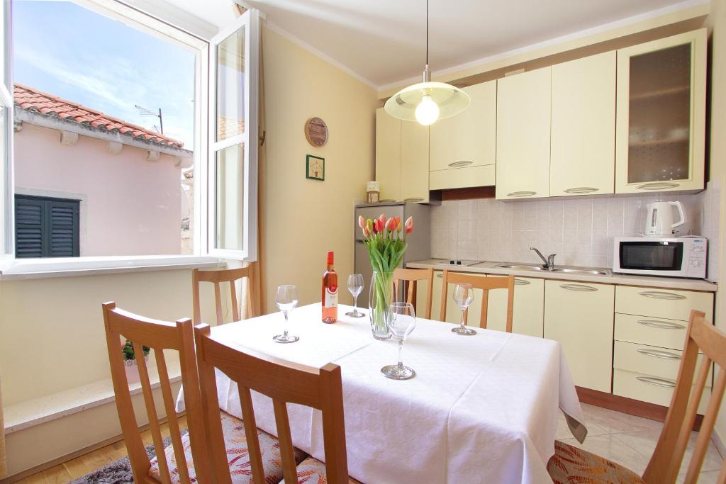 eine Küche mit einem Tisch und einer Blumenvase darauf in der Unterkunft Apartments Kovac Old Town in Dubrovnik