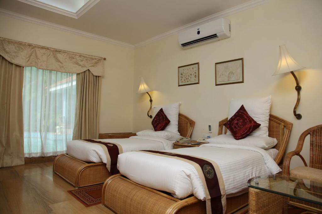 Postel nebo postele na pokoji v ubytování SAJ Earth Resort & Convention Center , Kochi